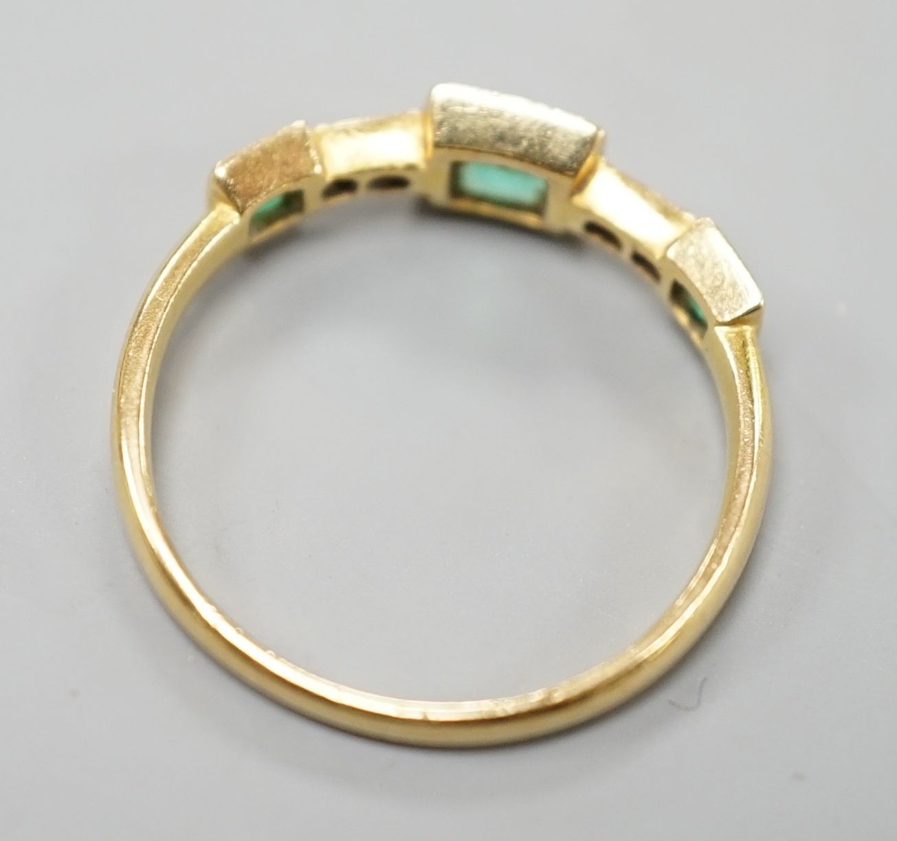 A George V 18ct gold, three stone emerald and four stone diamond chip set half hoop ring, size L, gross weight 1.8 grams.